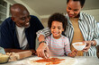 © Marko Geber - Happy family making homemade pizza together in kitchen