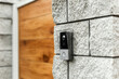 © annaartday - Smart video doorbell camera mounted on a modern stone wall entrance. Home security concept.