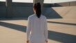 © QuoDesign - East Asian woman wearing a blank white sports jersey at a brutalist concrete stadium