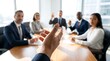 © CuteBee - First person view of person gesturing during business meeting with blurred colleagues in professional office setting