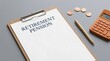 © Wankatsu - Retirement pension document on a wooden clipboard with a gold pen coins and calculator for financial security planning business lifestyle concept