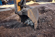 © Евгений Вершинин - Excavator bucket digging into urban construction site soil