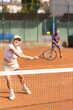 © JackF - Active elderly playing lawn tennis outdoors. Senior husband and wife spend weekends together and play sports