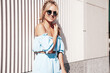 © halayalex - Portrait of young beautiful smiling hipster woman in trendy summer clothes. Sexy carefree woman posing in the street at sunset. Positive blond model outdoors. Cheerful and happy. In sunglasses