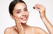 © Oleg Gekman - Young beautiful woman applying face serum with pipette. Cosmetic procedures for facial skin care