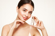 © Oleg Gekman - Beautiful elegant woman holding a cosmetic jar of oil serum or hyaluronic acid in her hand. Perfect facial skin