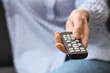 © Pixel-Shot - Hand holding television remote control changing channels, entertainment and leisure activity, home media consumption