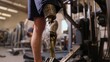 © Yanka - Closeup prosthetic leg on machine, adaptive athlete performing seated strength exercise in busy gym, socket and carbon components visible, focused leg press motion, intensive rehabilitation and power