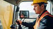 © Ivan - Man operator in yellow hard hat sitting inside excavator cab. Construction worker driving heavy machinery using joystick and digital display monitor. Professional site development equipment.