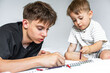 ©  Tsvyk L. - Teenage boy and his little brother drawing with pencils in sketchbook