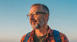 © MdTanvir - Mature man with glasses gazing away outdoor portrait with backpack