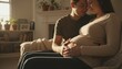 © K1drock - Affectionate pregnant couple sitting on a sofa in a sunlit living room, with the man gently touching the woman's baby bump, expressing love and anticipation for their future child.