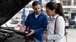 © rdkcho - Professional mechanic explaining car engine repair to a female customer at an auto repair shop