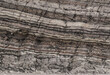 © David - Close up of layered sedimentary rock face showing distinct horizontal strata with varying shades of brown grey and white mineral deposits