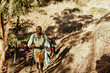 © Marko Geber - Group of hikers trekking uphill on dry mountain trail