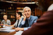 © Marko Geber - Senior professor listening during study group in library