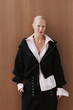 © Serge Filimonov/Stocksy - Portrait woman in black jacket over wood wall