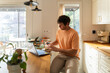 © Alba Vitta Studio/Stocksy - Man Works on Laptop in Kitchen
