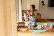 © Alba Vitta Studio/Stocksy - Woman Checking Mobile Phone in Kitchen