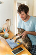 © Alba Vitta Studio/Stocksy - Man Works on Laptop With Cats in a Home Office