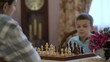 © MrP - Mom and son sit at the table and spend their free time playing chess.