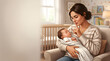 © Bayu - Mother holding a sleeping newborn baby in a nursery room while making a quiet gesture with her finger to her lips in a soft indoor setting
