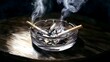 © decorator - Moody watercolor still life of cigarettes smoke curling from a glass ashtray on wood