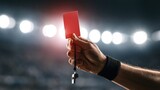 Referee holding up a red card during a soccer match under stadium lights.