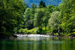 © JairoMZ - Peaceful section of the Kolpa River bordered by vibrant greenery and gentle rapids representing sustainable tourism and protected natural environments