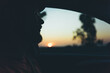 © Екатерина Лукашина - Silhouette of bearded man looking through car window at golden sunset during a peaceful evening road trip