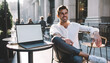 © Vicentia - Smiling handsome caucasian man working on a laptop at outdoor city cafe terrace, digital nomad lifestyle, remote online business, successful entrepreneur, urban freelance concept