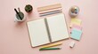 © Andika - Open spiral notebook with pencils, sticky notes, and a small plant for back to school layout. Creative student workspace desk mockup on a pink background.