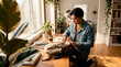© Rendara Studio - Young man packing backpack at sunny desk with plants in modern home