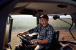 © Drazen - Happy agronomist driving tractor while working on farm.