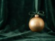 © AdPremium - Elegant gold Christmas ornament hanging by a green ribbon bow against a dark green velvet backdrop
