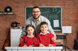 © Pixel-Shot - Smiling music teacher with young students learning piano in classroom, educational development and creative arts, the teacher and children are smiling