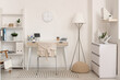 © Pixel-Shot - Interior of stylish home office with tablet computer, workplace and clock hanging on white wall