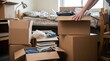 © velikiyzayats - Young adult student packing cardboard boxes with clothes and books for moving out of a college dormitory room, concept of relocation and transition to independent living