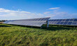 © Jan Habarta - Solar panels ground installation on green grass field producing clean renewable energy under blue sky with clouds