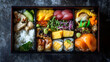 © beehu - Deluxe japanese bento box featuring assorted sushi sashimi and grilled fish on a dark textured background for gourmet asian cuisine presentation