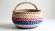 © Nusrat - Round rope basket with braided beige, pink, and blue stripes, symbolizing decorative craftsmanship, woven design, and functional artistry.