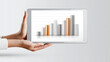 © Achirawee - A pair of hands holding a tablet displaying a graph that shows the correlation between interest rates and investment performance, set against a clean background with ample copy space.