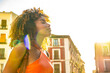 © unai - Young woman enjoying sunshine in city street