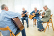 © Westend61 - Seniors in retirement home attending guitar class, making music