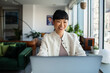 © Marko Geber - Smiling businesswoman working on laptop in modern office