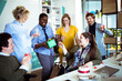 © Davor - Coworkers celebrating birthday with gift in modern office