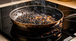 © Вадим Перегудов - Burnt food smoking in a frying pan on a glass stovetop. Ruined meal and cooking disaster in a domestic kitchen. Fire hazard and culinary failure concept