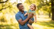 © ADPShapla - Happy father holding his young son in a sunny park during the autumn season