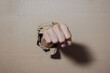 © Chandet - Close-up of a human fist punching through corrugated cardboard, tearing a hole in the cardboard texture.