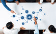 © InfiniteFlow - A diverse group of professionals engaged in a collaborative business meeting, analyzing strategic concepts represented by digital icons and connections on a large table. Amity